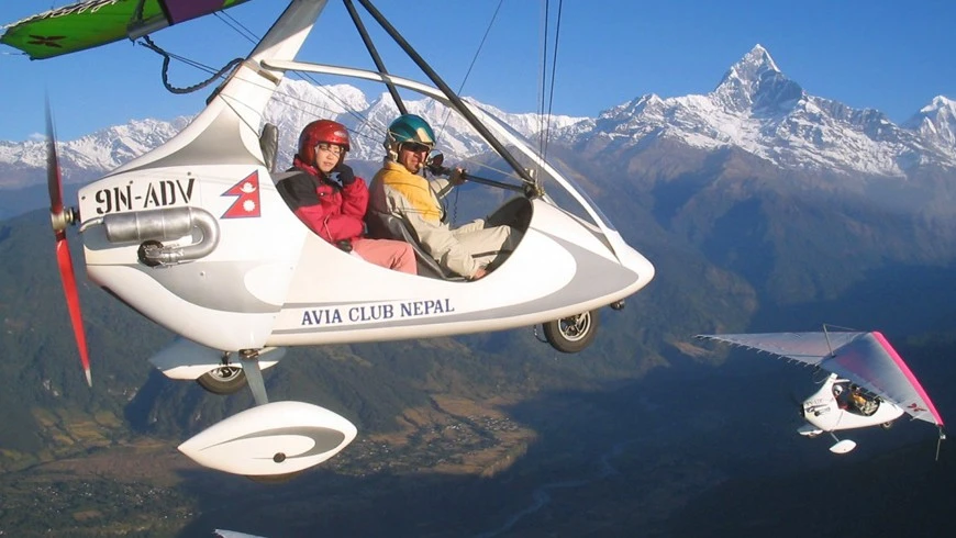 Pilot and passenger in Ultra Light Flight with Machhapuchre Himal in the Back