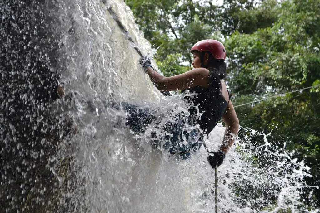 A girl doing  Canyoning in waterfall